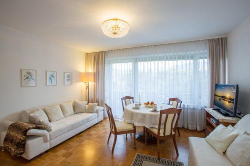 a living room with a white couch and a table at Landhaus Alpenblick in Garmisch-Partenkirchen