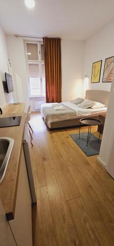 a bedroom with a bed and a kitchen with a sink at Noble Studio Apartments in Zagreb