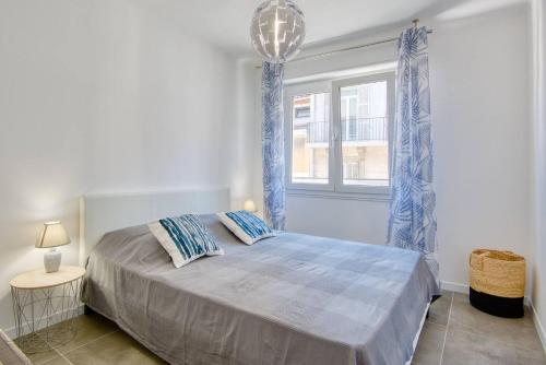 Schlafzimmer mit einem Bett mit blauen Vorhängen und einem Fenster in der Unterkunft Sainte-Catherine - Superbe appartement avec balcon Vieux-Port in Marseille