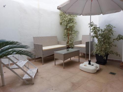 a patio with chairs and an umbrella and plants at Despo's Apartment in Volos
