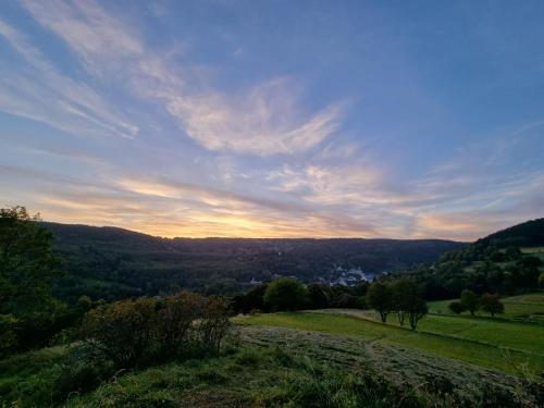 a view of a field at sunset from a hill at Apartmán Uršula in Jáchymov