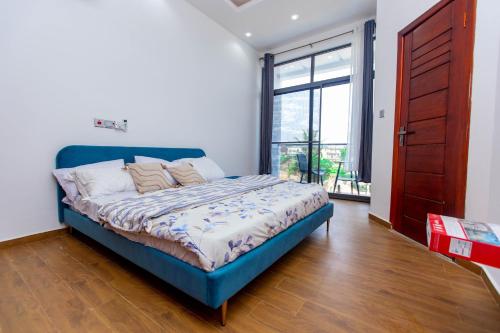 東勒貢的住宿－2 bedroom at East Legon, excellent location，一间卧室设有蓝色的床和大窗户