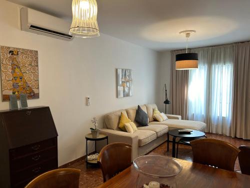 een woonkamer met een bank en een tafel bij Mara Arenal Sevilla in Sevilla