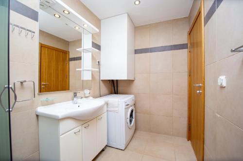 y baño con lavadora y lavamanos. en Blue Horison Apartments by In Property en Pržno