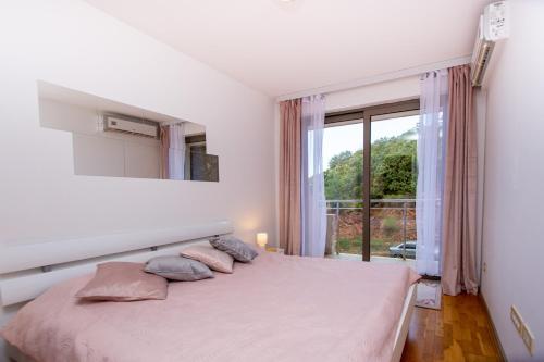 Habitación blanca con cama y ventana en Blue Horison Apartments by In Property en Pržno