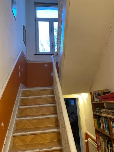 a staircase with a window and a book shelf at Brussels Guesthouse - Private bedroom and bathroom in Brussels