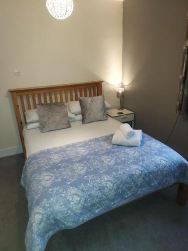 a bedroom with a bed with a blue blanket at 4B Wentworth Street Apartment in Portree