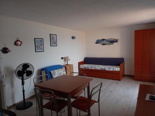 a living room with a table and a bed at APPARTAMENTO SUL MARE CON TERRAZZA in Marinella