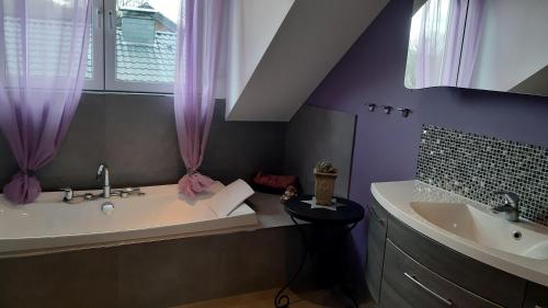 ein lila Badezimmer mit einer Badewanne und einem Waschbecken in der Unterkunft Wohnung mit 5 Einzelzimmern in Selm
