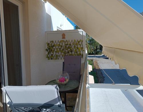a table and a chair on a balcony with an awning at G.S. Studio 2 in Mastichari