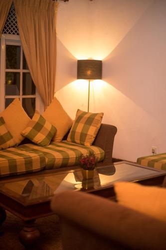 a living room with a couch and a table at Udapola Bungalow by Lalan Leisure in Deraniyagala