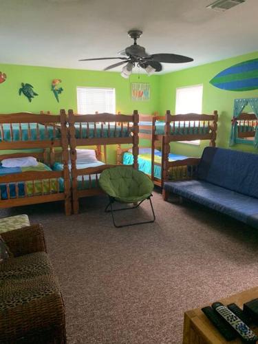 a room with two bunk beds and a couch at The Aloha Beach in Surfside Beach