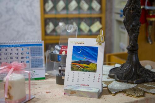 a table with a calendar and a candle and a lamp at Hotel San Marco in Rionero in Vulture