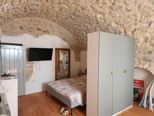 ein Schlafzimmer mit einem Bett und einer Steinmauer in der Unterkunft Casa Vacanze della zia Gargano in Mattinata