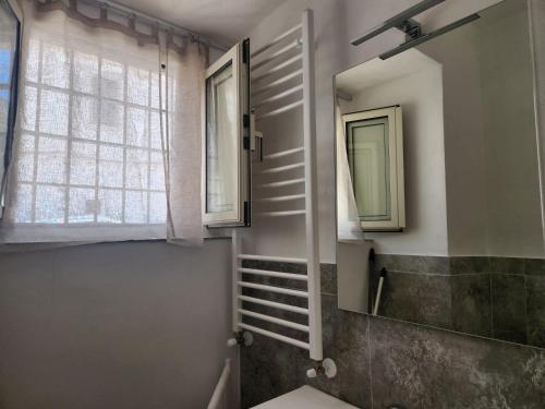 baño con lavabo, espejo y ventana en Casa Vacanze della zia Gargano en Mattinata