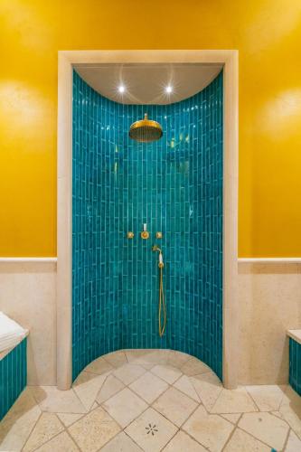 a bathroom with a shower with blue tile at Palazzo Matteo in Nardò