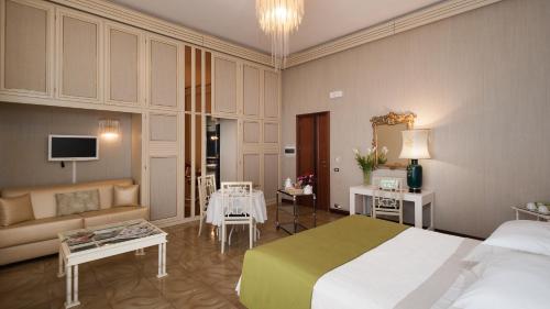ナルドにあるBoutique Villa Magnolia Luxury Suitesのベッドとリビングルームが備わるホテルルームです。