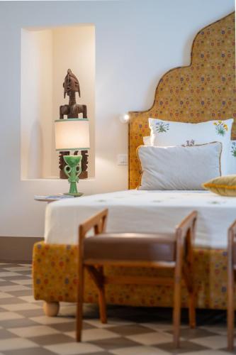 a bedroom with a large bed with a yellow headboard at Palazzo Matteo in Nardò
