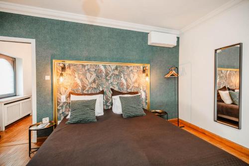 a bedroom with a large bed with green and white pillows at Porta Superia Boutique B&B in Mechelen