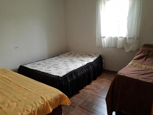 2 camas en una habitación con ventana en Chacara dos ipes, en São Roque