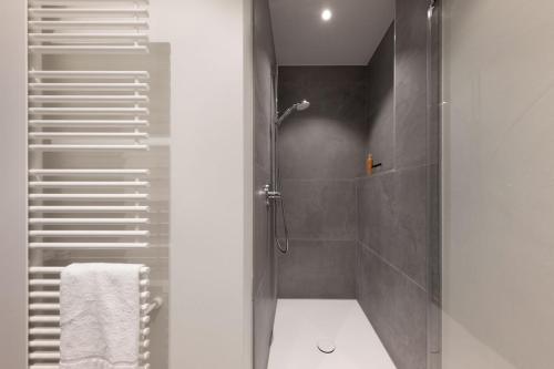 a bathroom with a shower with a glass door at Brera Serviced Apartments Munich Schwabing in Munich
