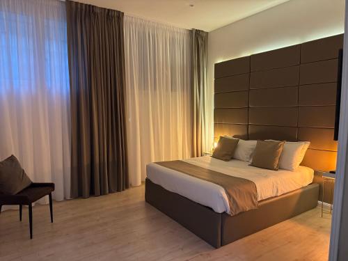 a bedroom with a large bed and a chair at NapoliOn - Luxury Apartment in Naples