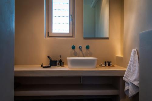 a bathroom with a white sink and a window at Milia Gi Suites in Pollonia
