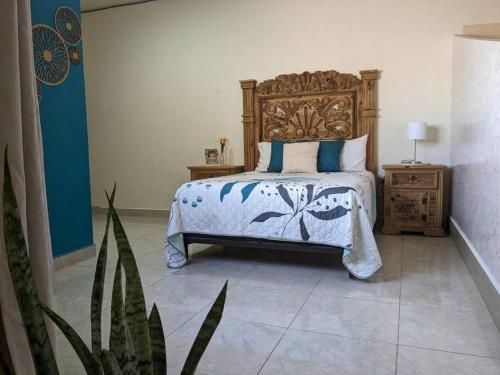 a bedroom with a bed with a wooden headboard at Estudio Balandra cerca del aeropuerto SJD in San José del Cabo