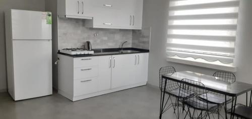 a kitchen with a white refrigerator and a table and chairs at Emir Hotel Belek in Serik