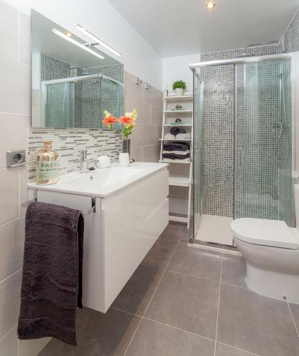 a bathroom with a sink and a shower and a toilet at Los Rosales Apartamento in Cala Millor