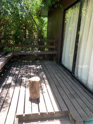 una terraza de madera con un cubo de basura. en Cabañas pucon, en Pucón