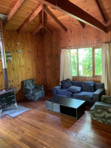 a living room with a couch and a table at Cabañas pucon in Pucón