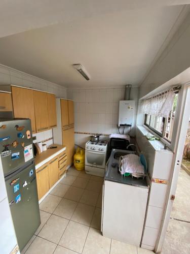 a small kitchen with a refrigerator and a stove at Casa Quintero in Quintero