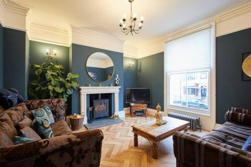 a living room with a couch and a fireplace at Deja Blue Beautiful period property in Whitby