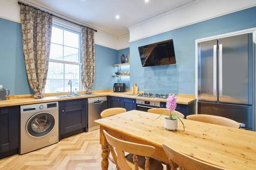 a kitchen with blue walls and a wooden table at Deja Blue Beautiful period property in Whitby