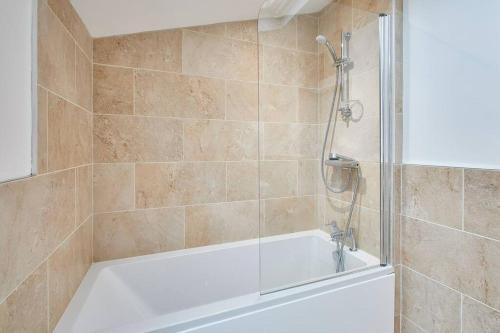 a bathroom with a shower and a bath tub at Deja Blue Beautiful period property in Whitby
