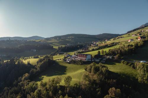 an aerial view of a farm in the hills at Panoramahotel Huberhof in Maranza