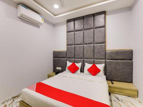 a bedroom with a large bed with red pillows at HOTEL KRISHNA in Ahmedabad