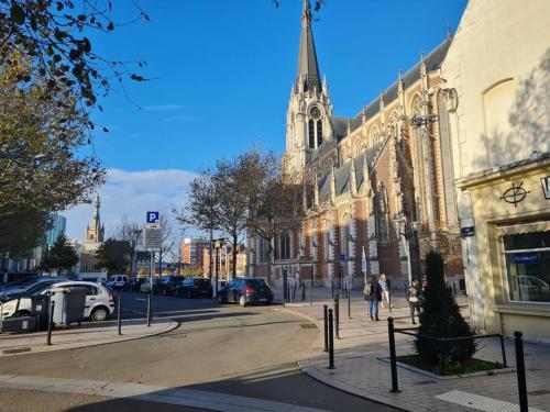 a city street with a large building and a church at Bel appartement 3 suites privatives hyper centre in Tourcoing