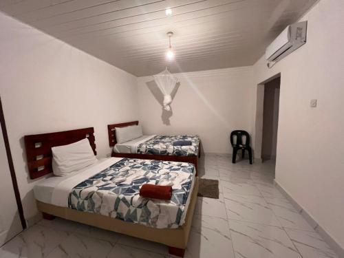a bedroom with two beds and a ceiling at Kasuba Apartments in Livingstone
