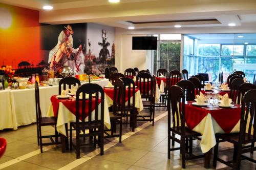 a dining room with tables with red and white table cloth at Plaza Real Hotel in Encalada