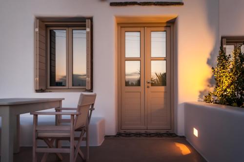 a room with a table and chairs and a door at Milia Gi Suites in Pollonia