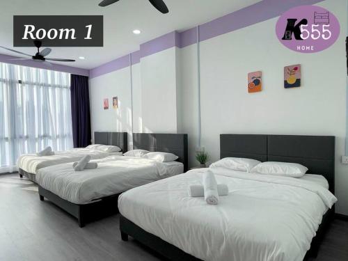 Un dormitorio con dos camas con sábanas blancas. en K555 Home Stay, en Kuala Terengganu