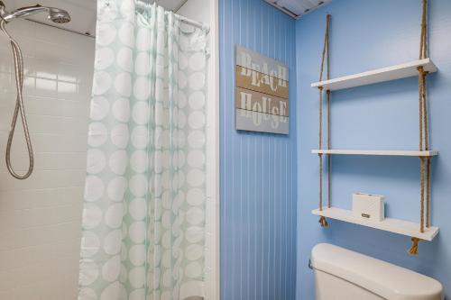 a bathroom with a shower curtain and a toilet at Cozy Ocean City Condo Steps to Maryland Beach! in Ocean City