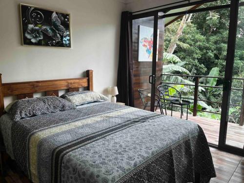 a bedroom with a bed and a sliding glass door at Casa Colibrí in Tilarán