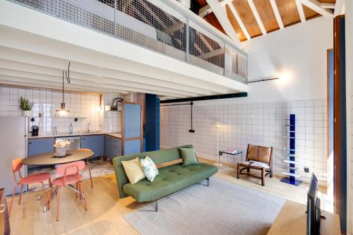 uma sala de estar com um sofá verde e uma mesa em UMA Foyer 25 Apartments no Porto