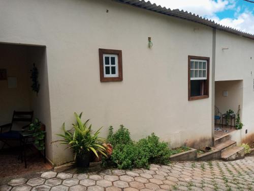 a white house with a window and a patio at Villa a arte de Minas in Tiradentes