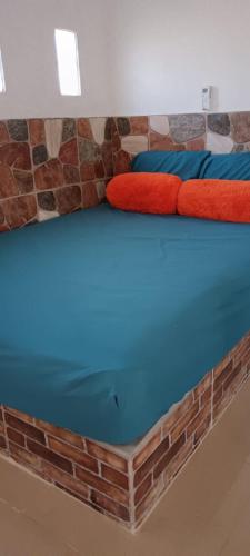 a bed with blue and red pillows on it at Casa Blanca 
