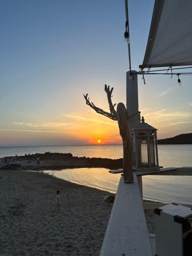 a statue of a person on the beach at sunset at Villa La Caletta in Carloforte