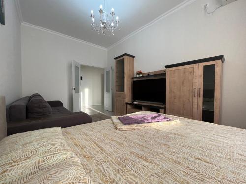 ein Schlafzimmer mit einem großen Bett und einem Sofa in der Unterkunft Однокомнатные бизнес апартаменты в ЖК Заман in Atyrau